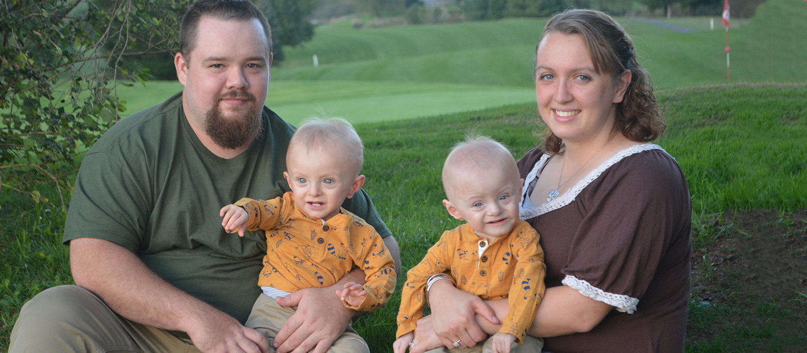 Mother and father smile while holding twins