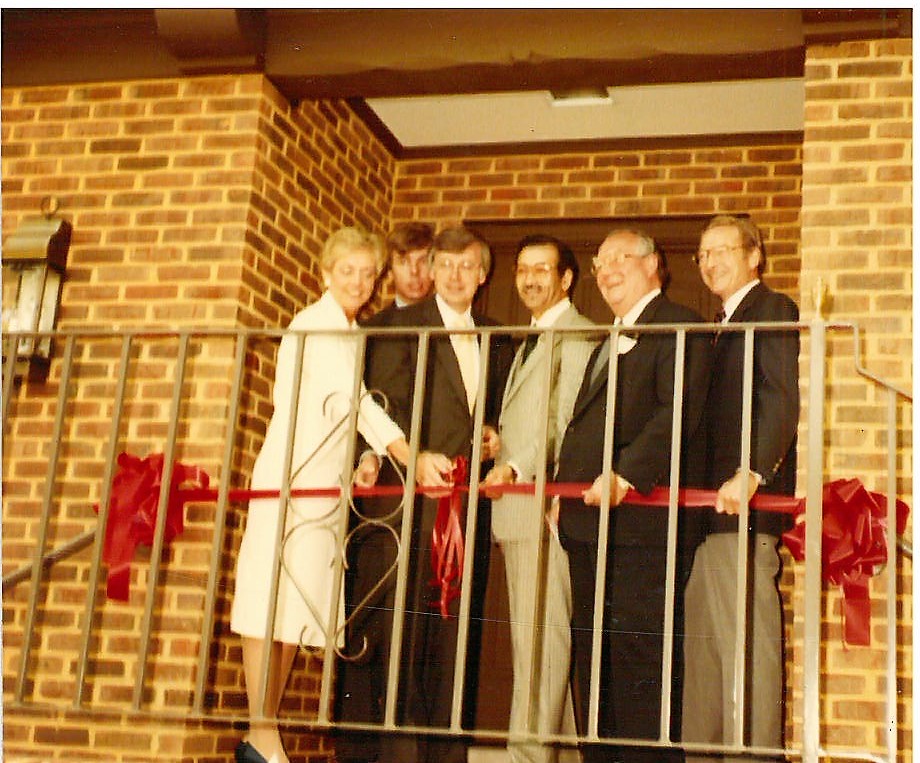 Group of people smile at Ribbon Cutting ceremony