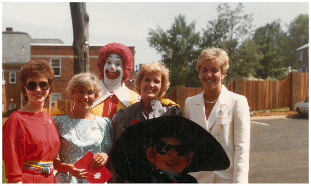 Group of people smile with Ronald McDonald and Hamburglar characters